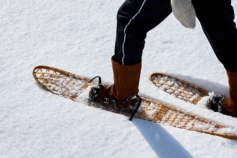 Person walking in snowshoes across deep snow